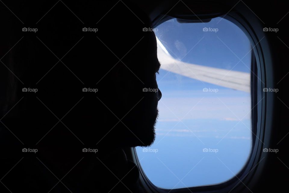 A man watching from airplane window 