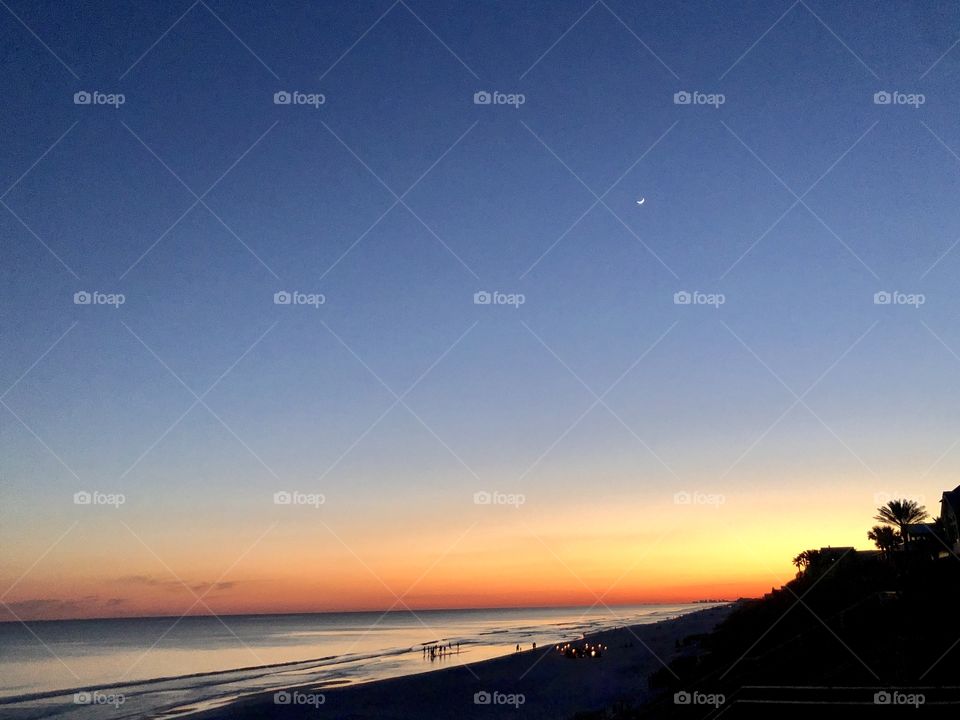 Nightfall over beach with sunset horizon and holiday gathering 