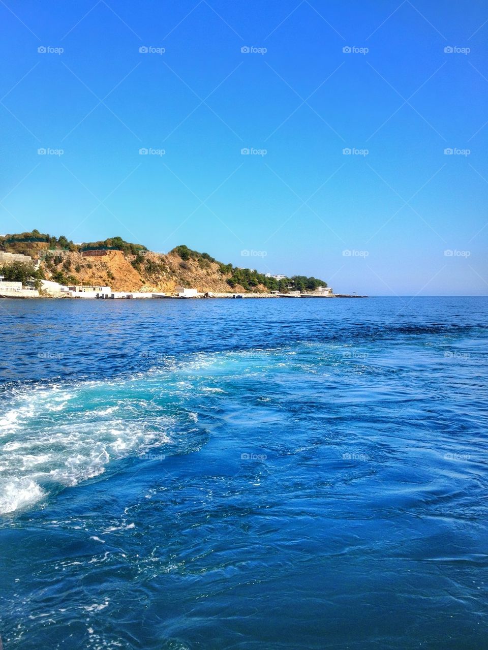 View of blue sea water with mountains in background