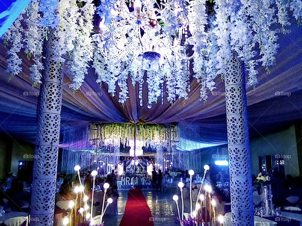 White lovely creative chandeliers with vibrant lights at the background, a beautiful party arrangements.