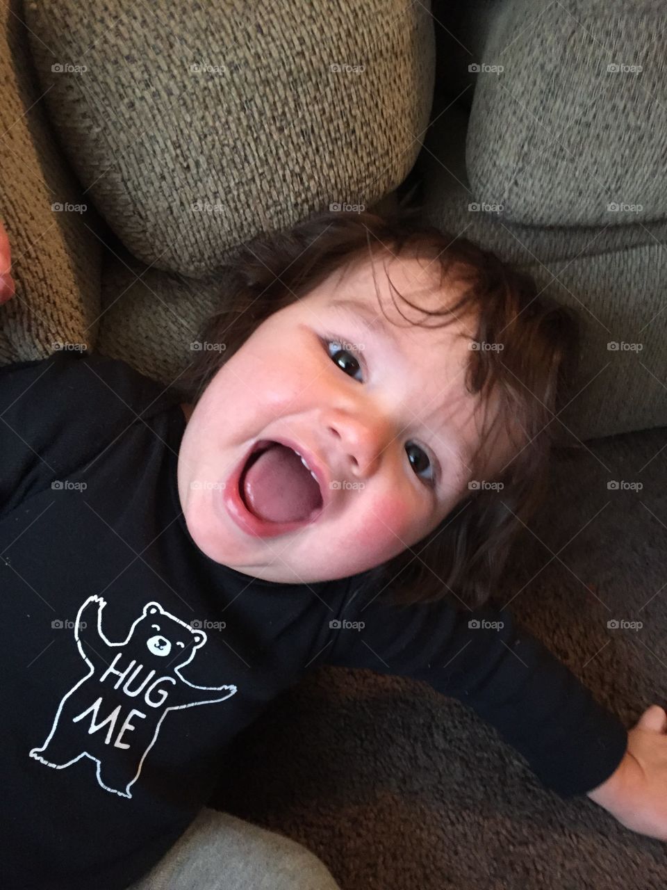 Baby boy being tickled by grandma and he is laughing.