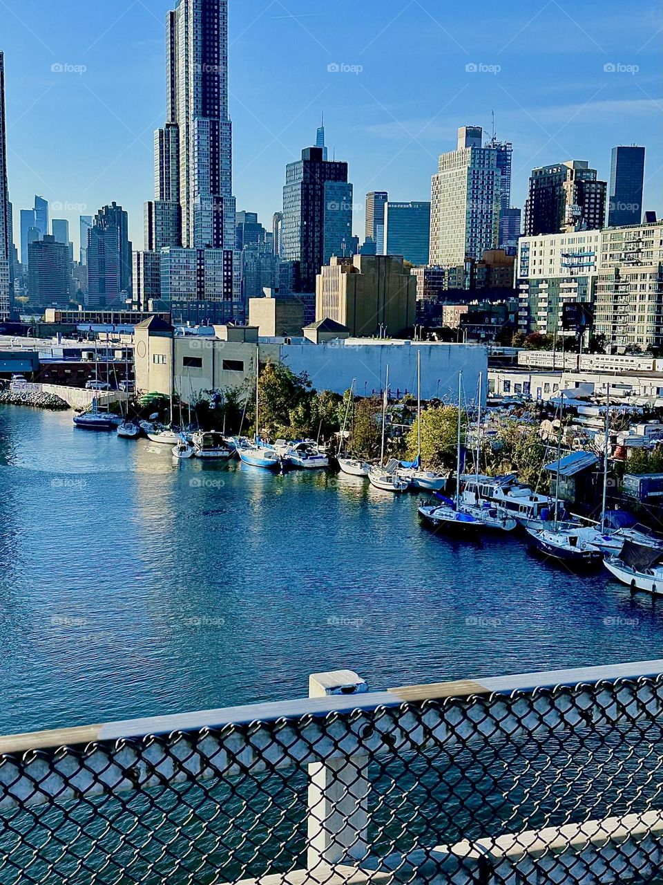 This is “Newtown Creek” seen from the “Pulaski Bridge” that connects “Greenpoint”, Brooklyn to LIC, Queens with a great variety of boats that are tied to the shore here on a warm sunny Indian summer day in early November 2023. Hypnotic Productions