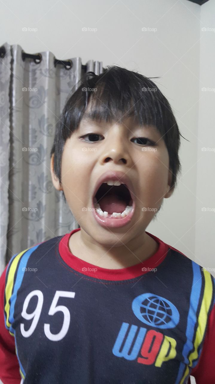 young boy showing his first loose tooth