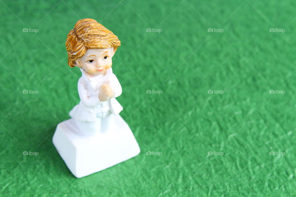 miniature white doll boy praying