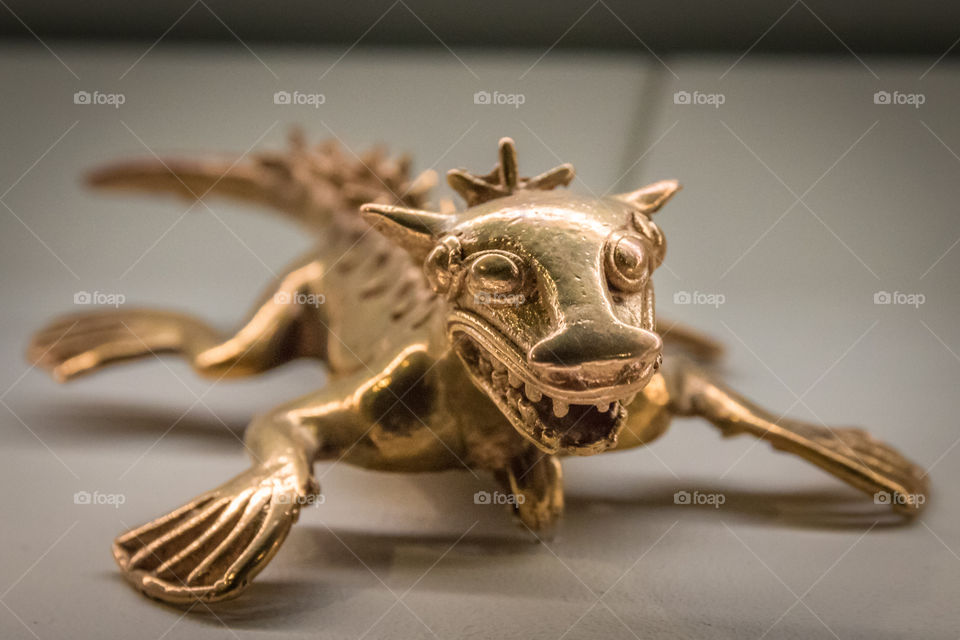 Closeup of gold pre-Columbian statue that looks like a dragon or iguana