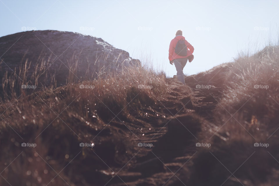 Woman hiking in the mountains. Silhouette of woman hiking at sunset