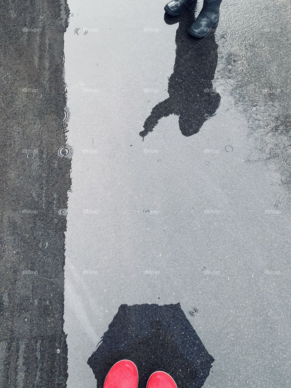 Umbrella and child shadow at puddle 