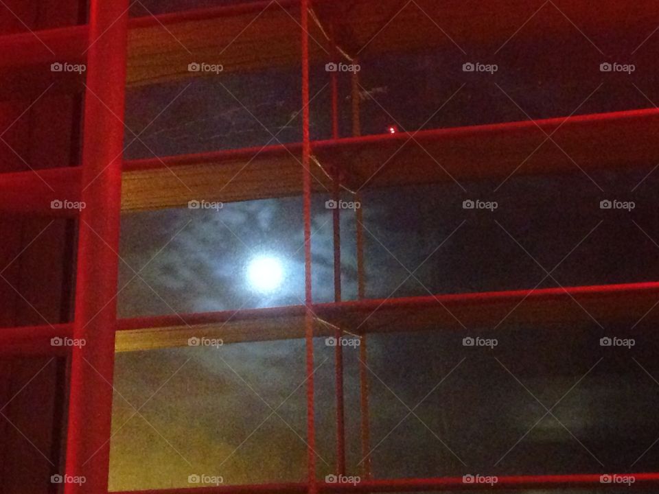 Full moon through orange window blinds 