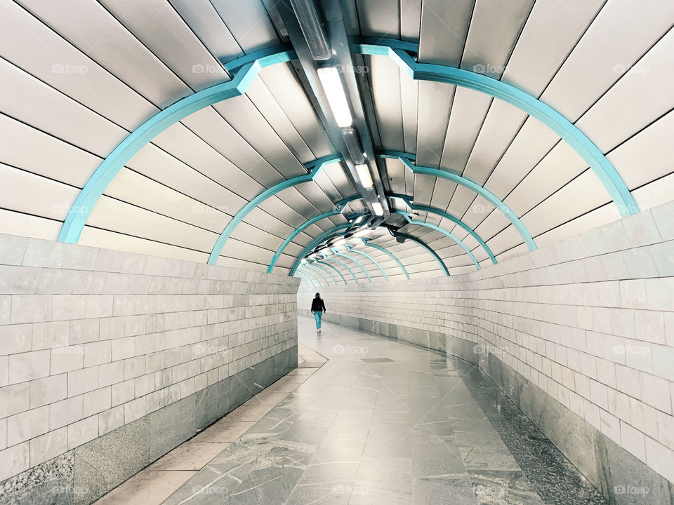 Tiny human in blue and grey tunnel 