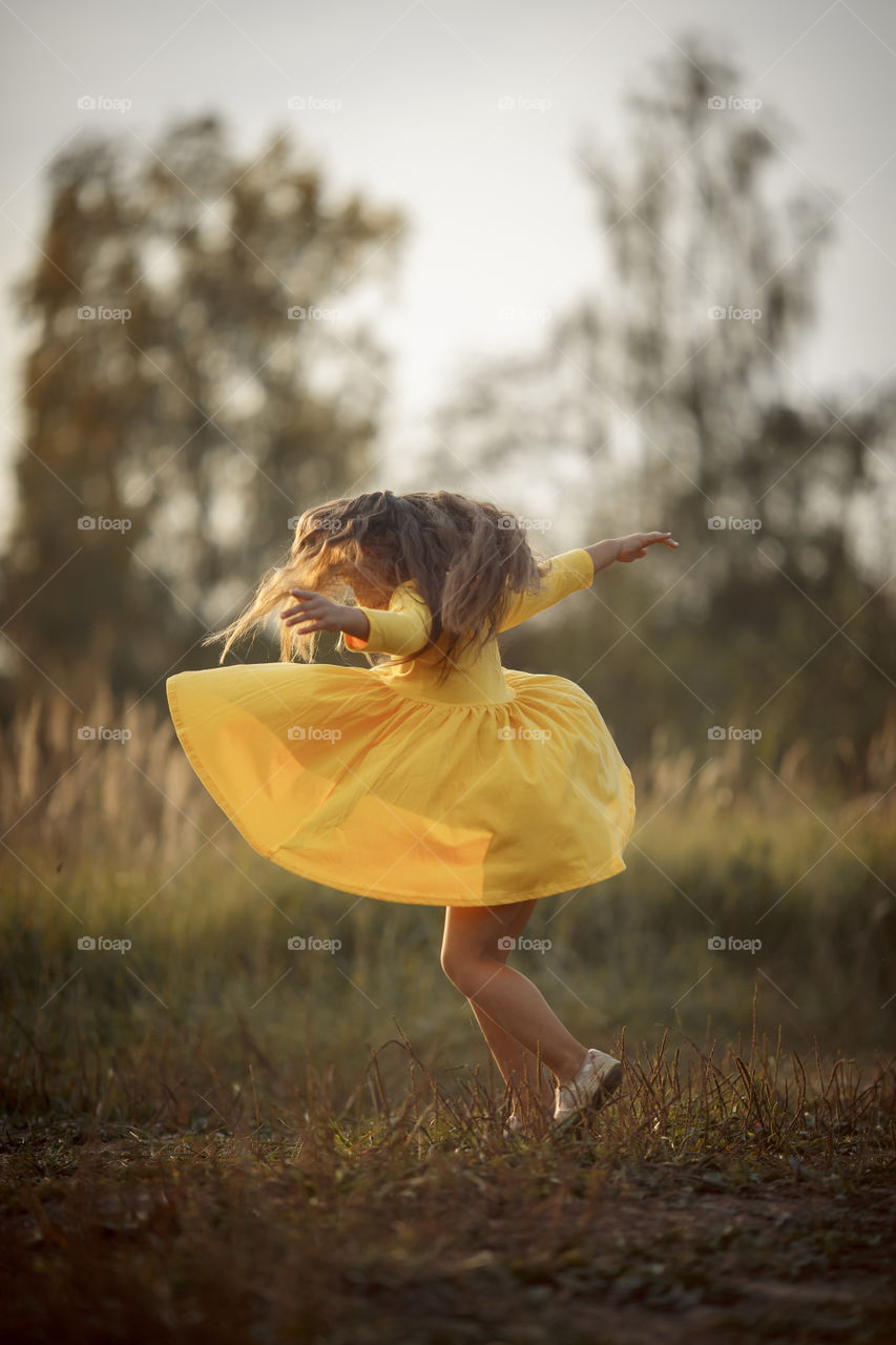 Little girl in yellow dress outdoor portrait 