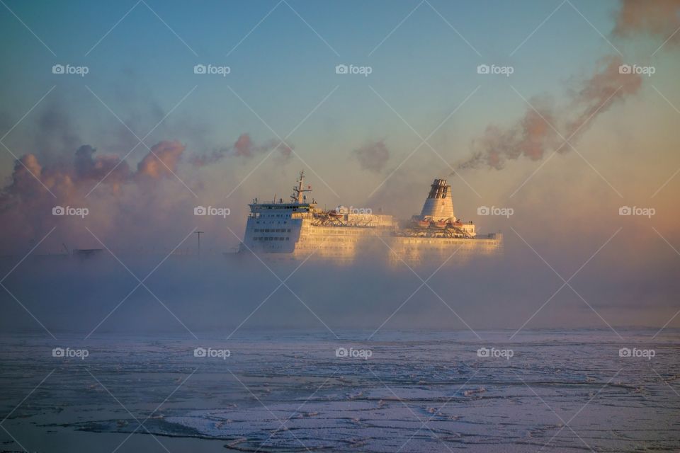 Ferry from Russia approaching Helsinki South harbor in extremely cold winter morning in the middle of thick mist, fog or winter sea smoke that is arising from the rapidly freezing Baltic Sea on 7 January 2016 in Helsinki, Finland.