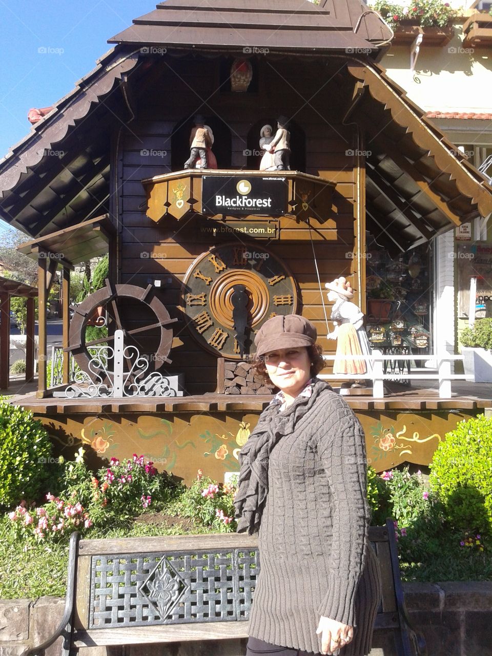 Woman standing in front of wooden clock in park
