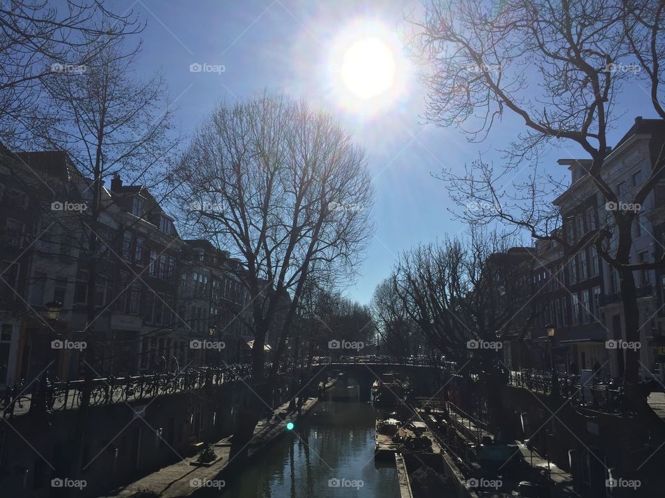 The famous Old Canal in Utrecht with the Sun shining brightly 