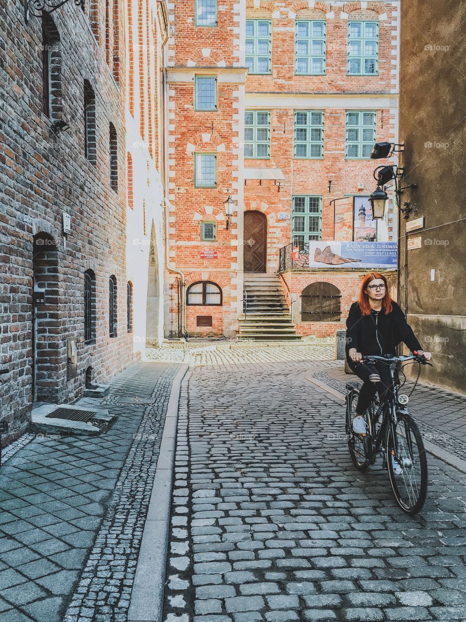Woman riding bicycle in alley