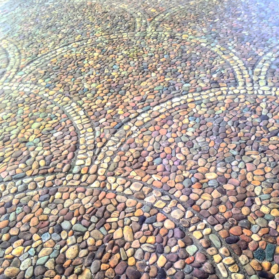 Colorful stone floor under a pool arranged in curved arching patterns