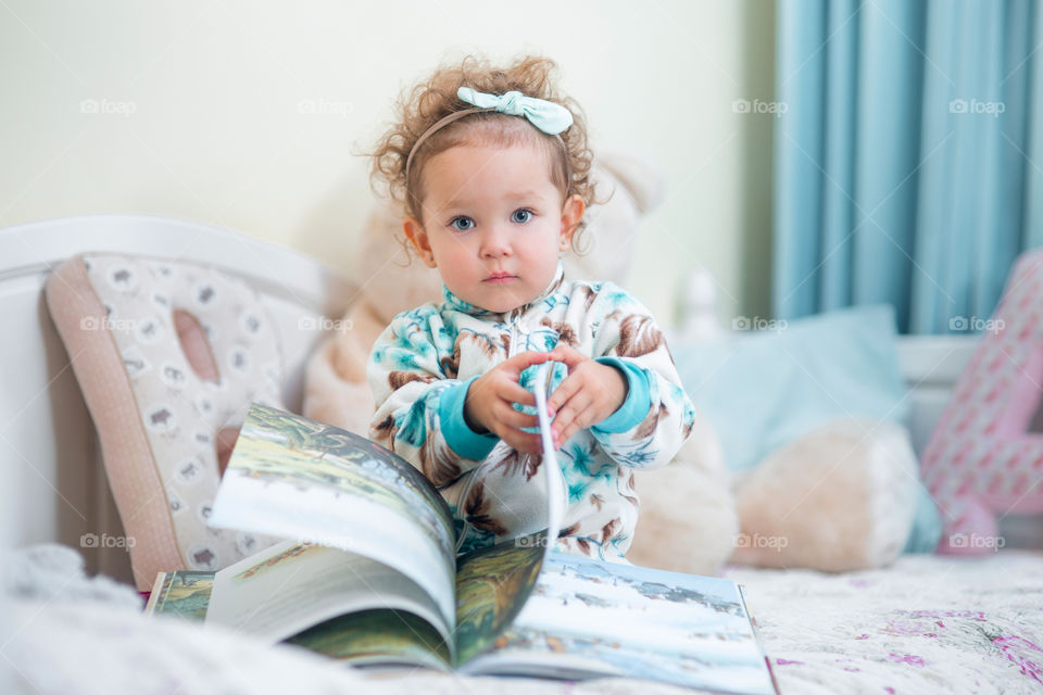 Cute little girl reading a book