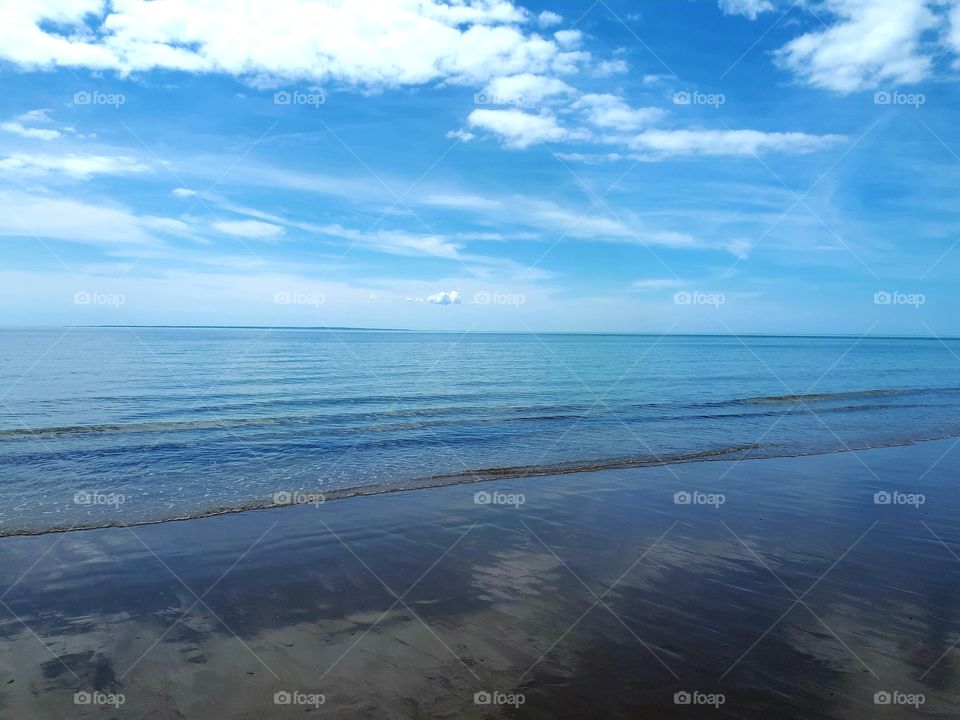 sea and clouds with clouds reflection on the water.
