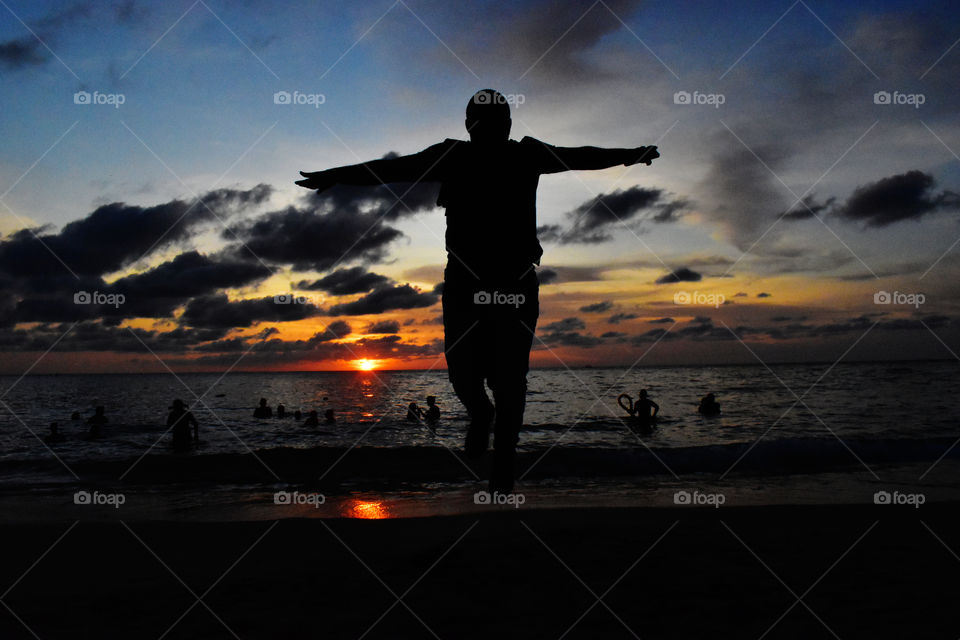 Silhouette of man flying with a beautiful sunset background