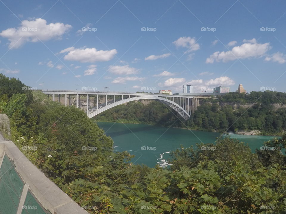 A shot of a bridge that connects the United States and Canada over Niagara Falls from Canada.