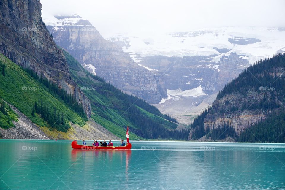 A red canoe stands out against the blue water of Lake Louise Canada .. such an awesome lake 