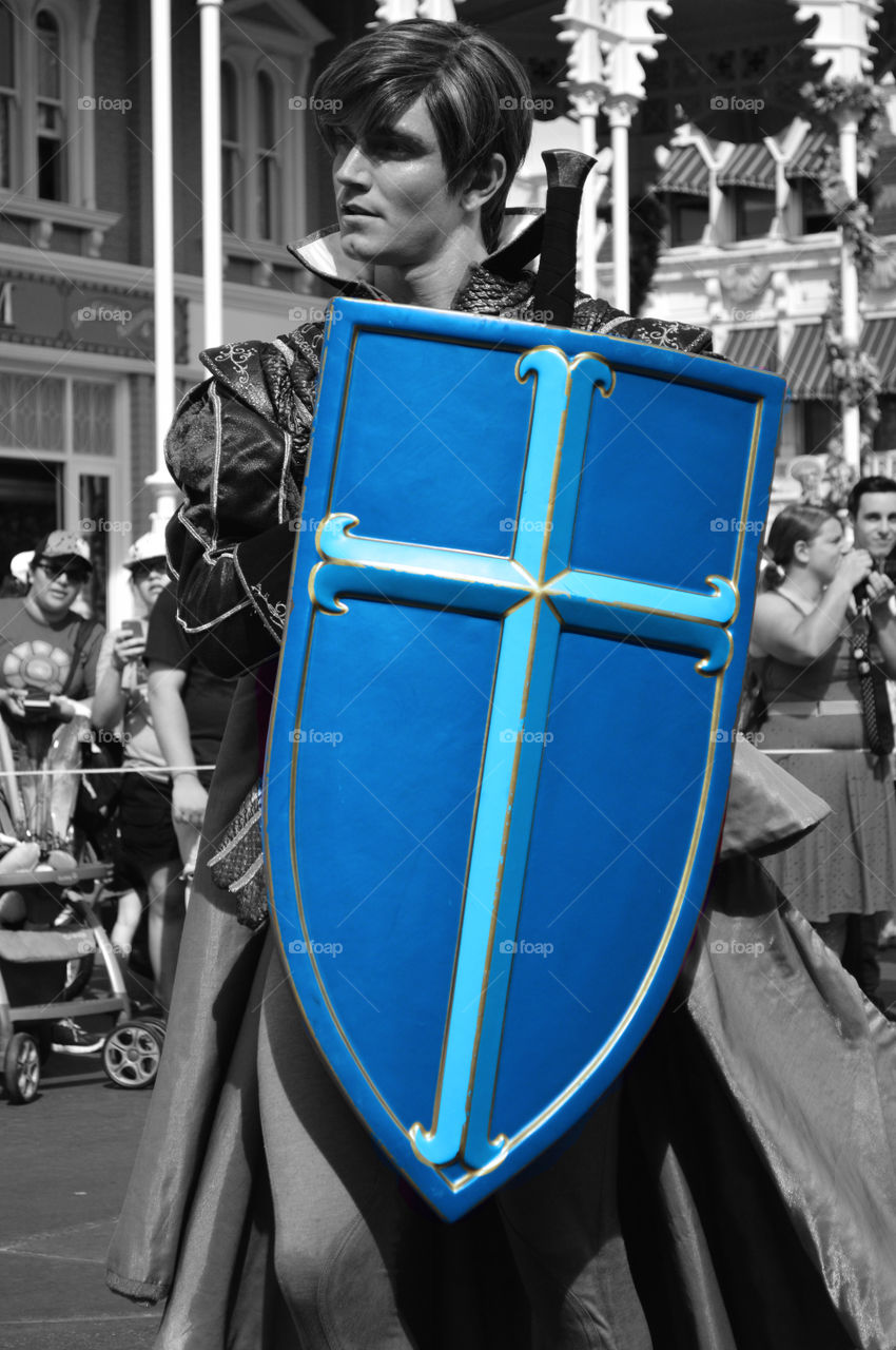 Man wearing costume with holding shield