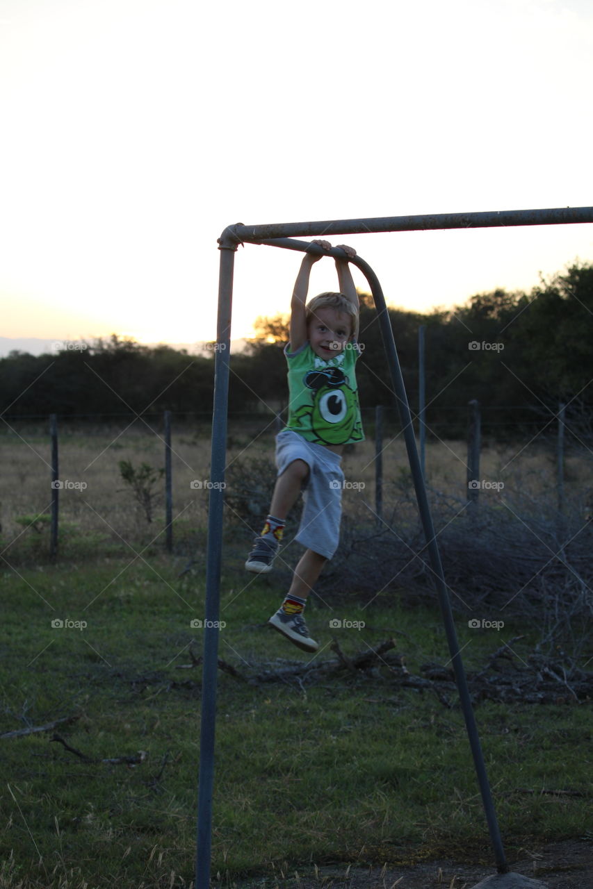 boy hanging on soccer goal