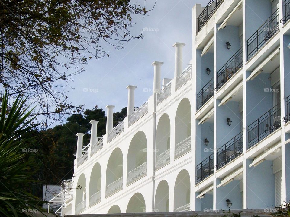 Stark white arches of this building are highlighted with the sunlight and the repetition of the balconies adjacent to it make for an abstract composition 
