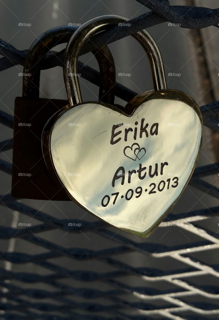 love padlock at a bridge with two names written on it