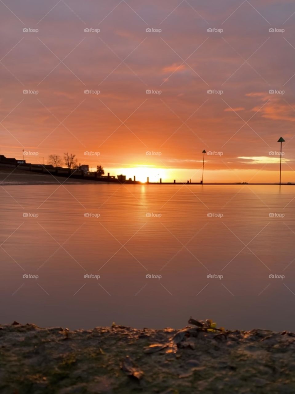 A warm beach sunrise scene with reflections on the water 