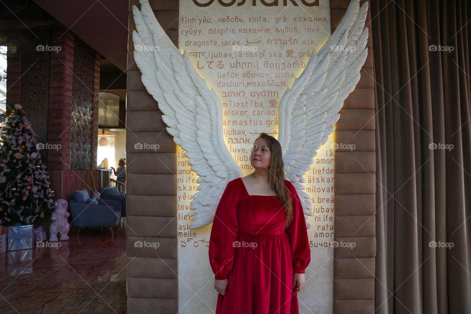 Woman in red dress and white wings 