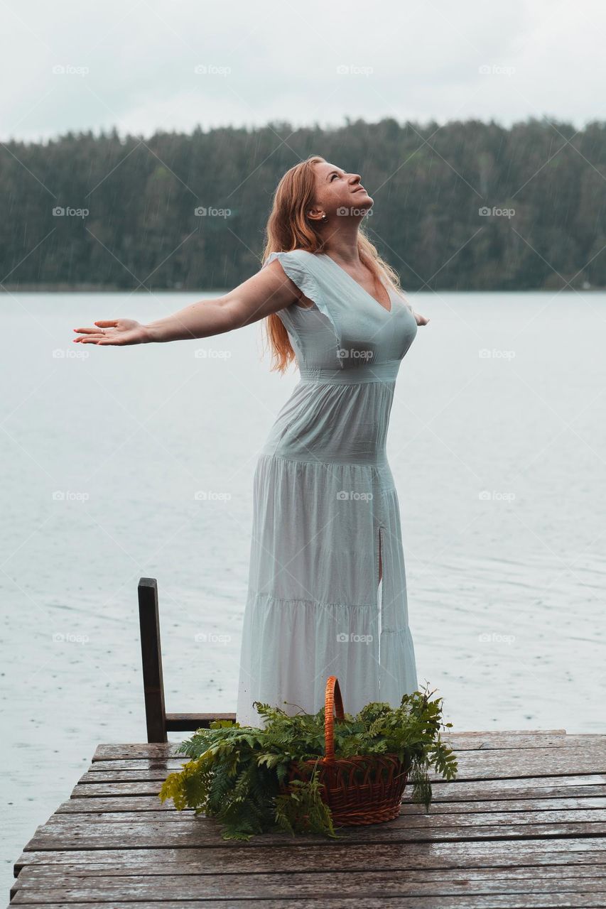 Middle aged ginger red woman staying under rain