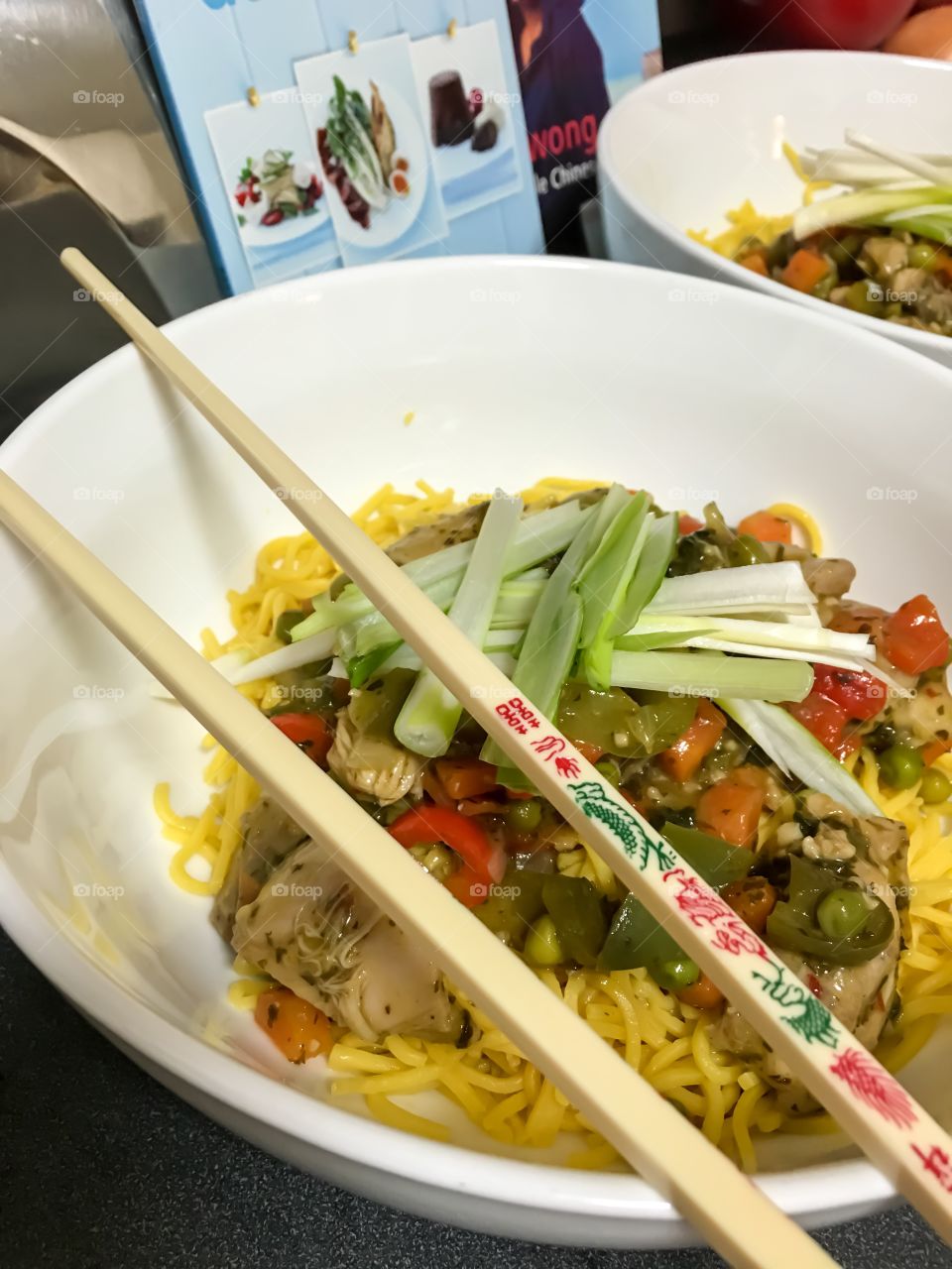 Thai basil chilli chicken and vegetables in white bowl with chopsticks closeup Asian Thai food