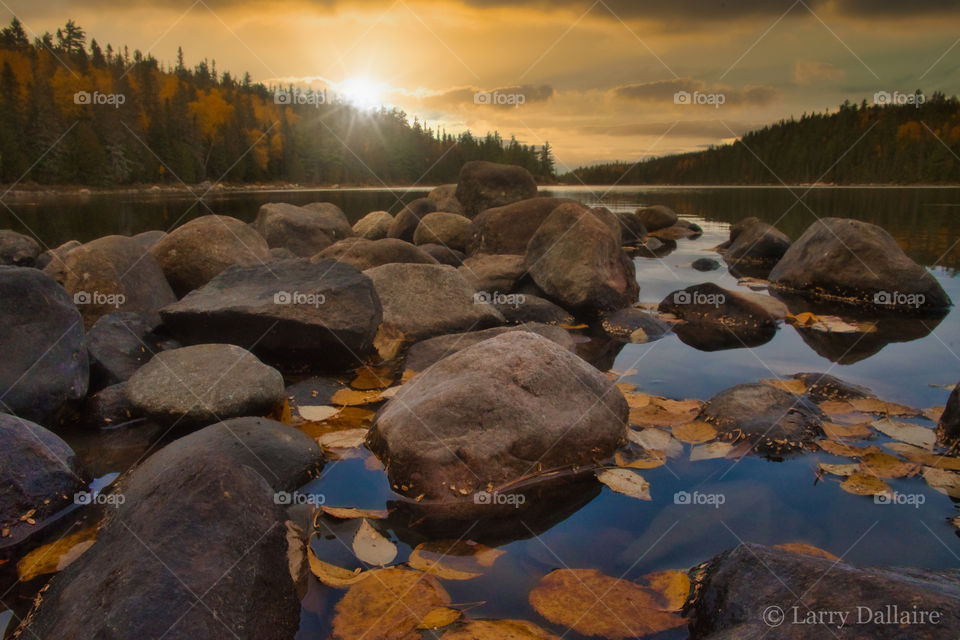 Sunset over lake and rocks, Quebec, Canada