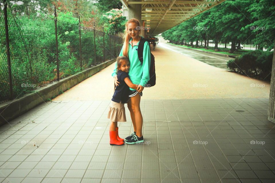 Mother and daughter at bus station 