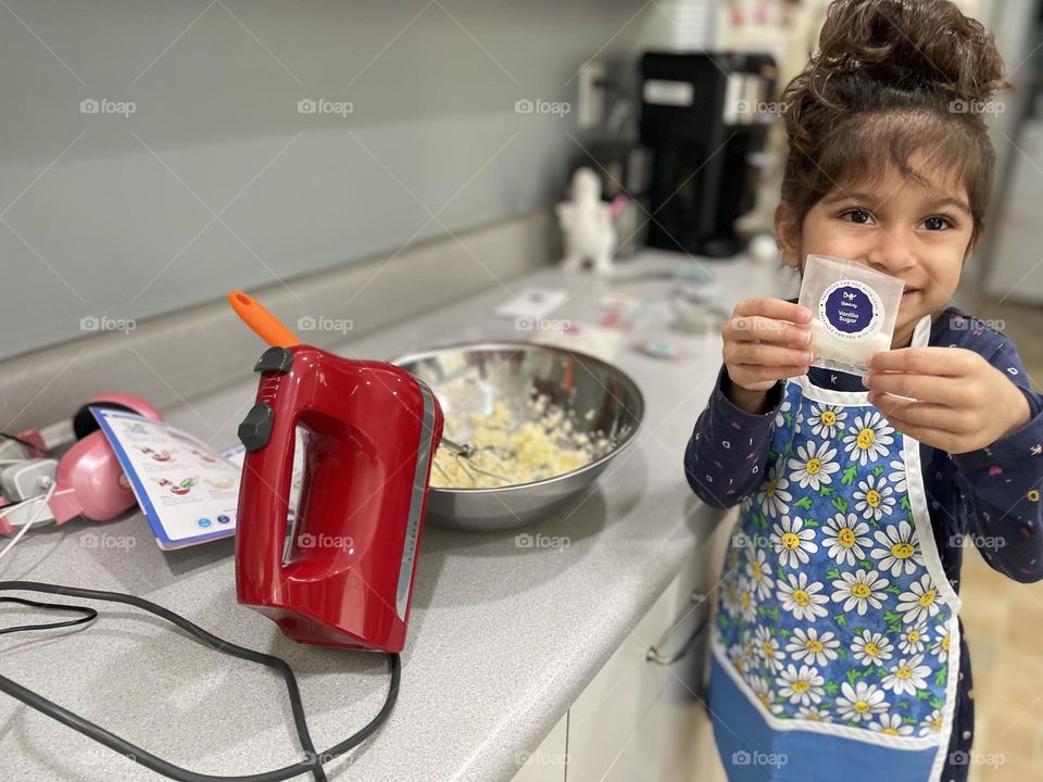 Little girl shows ingredients while baking, baking with mommy, creatively baking at home, baking unicorn sugar cookies 