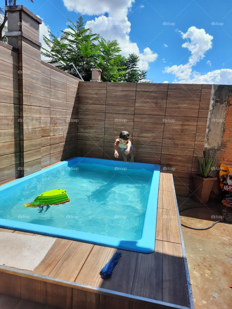 child jumping in the pool cooling off