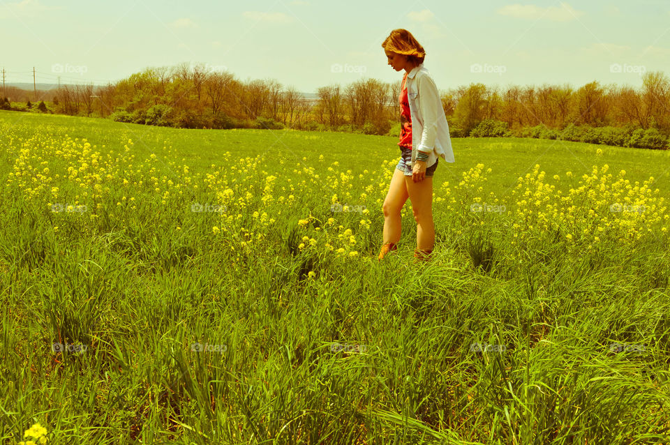 Woman walking in a field of flowers