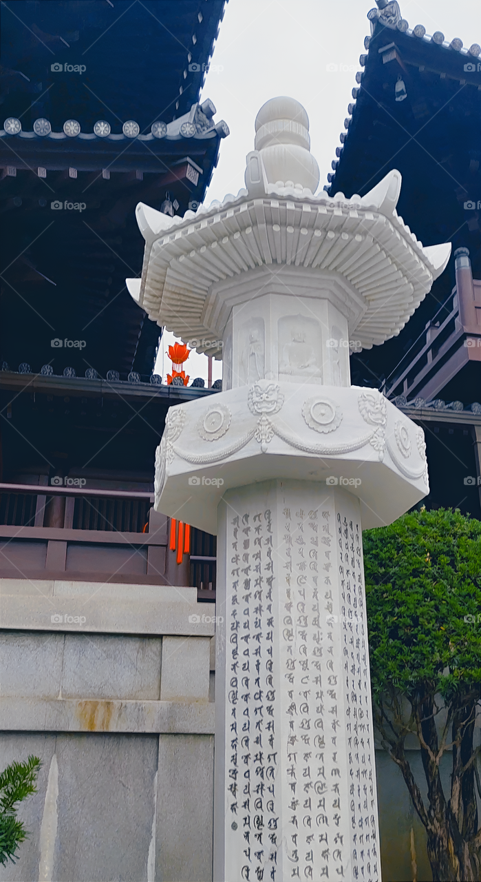White stone pillar engraved with Buddhist scriptures.