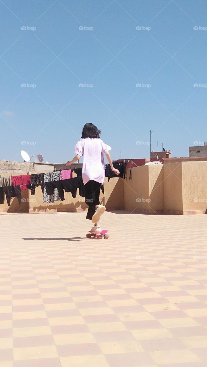 a young adult playing skate board.