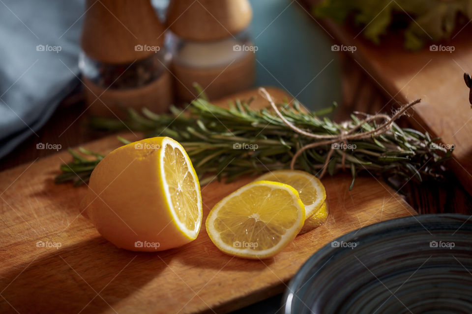 Lemon with rosemary on wooden board