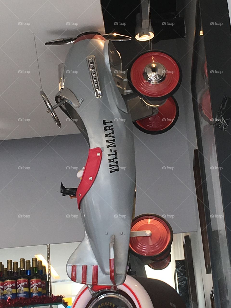 Airplane bicycle, Wal-Mart logo on the side. Hanging from the ceiling in the ice cream shop.