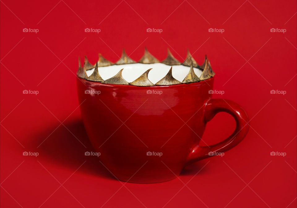 Red cup with spikes on red background