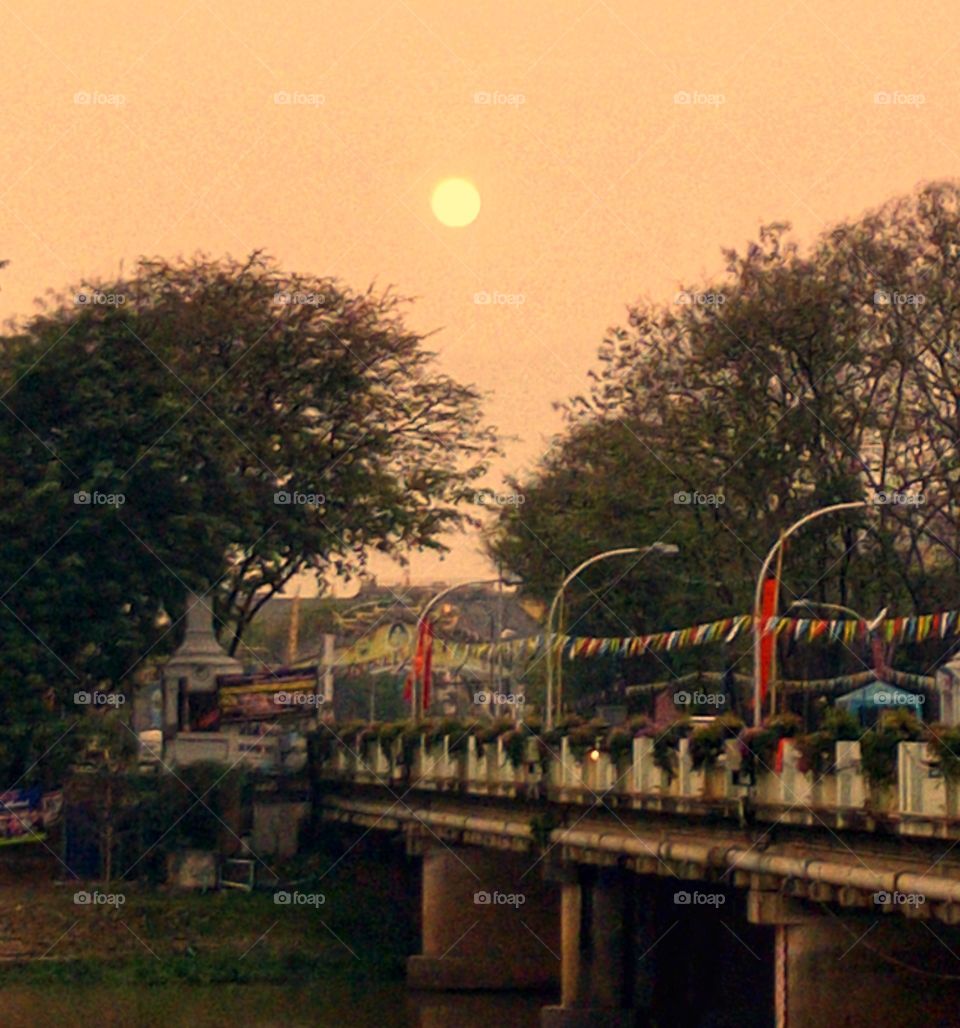 Bridge over the river overlooking the sun in the evening