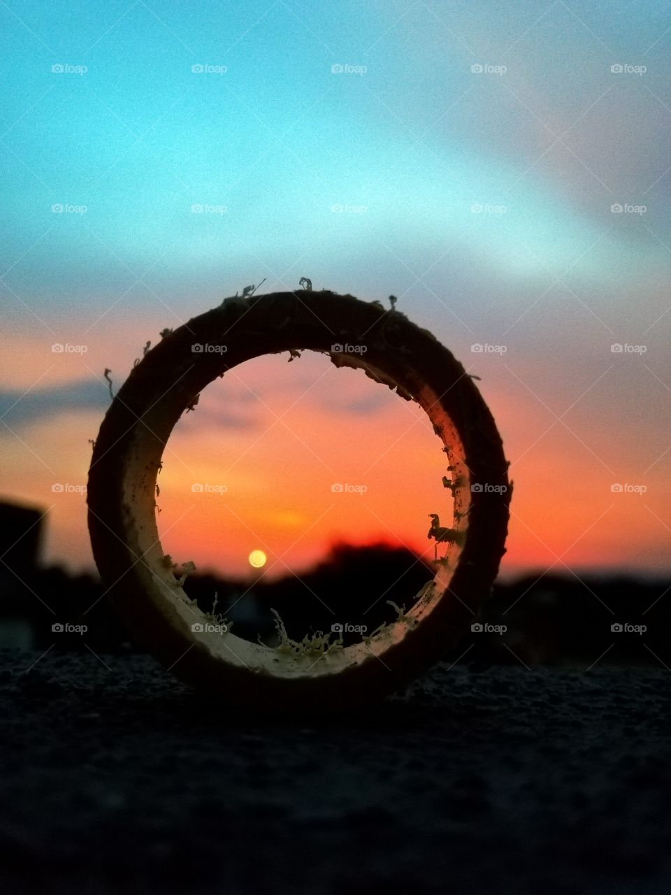 Sunset or sunrise through a ring: orange, red, blue, focus