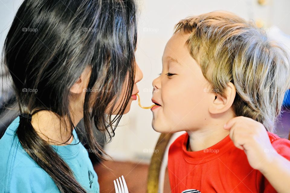 Let's eat bro! Big sister and little brother shared their noddle at happy meal time. 