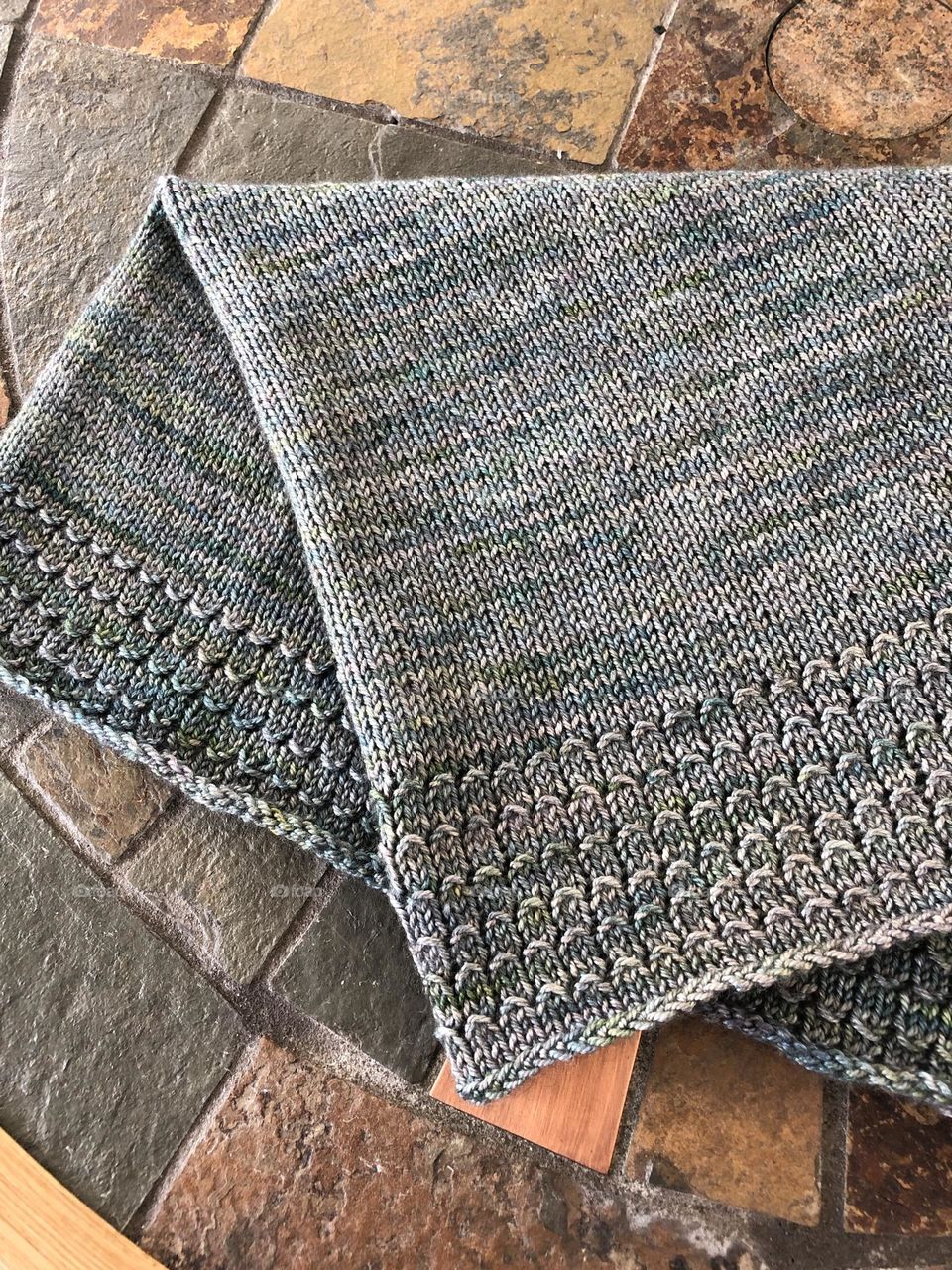 Warm and cool -hand knit cowl on stone table