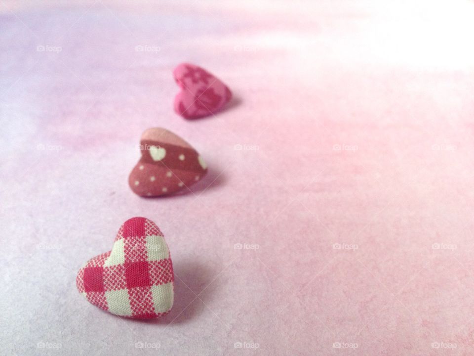 Three heart button on watercolor background 