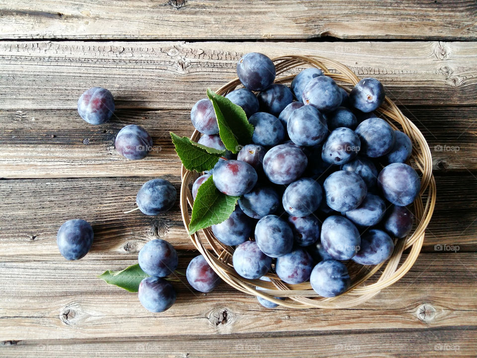 Tasty plums on wooden background