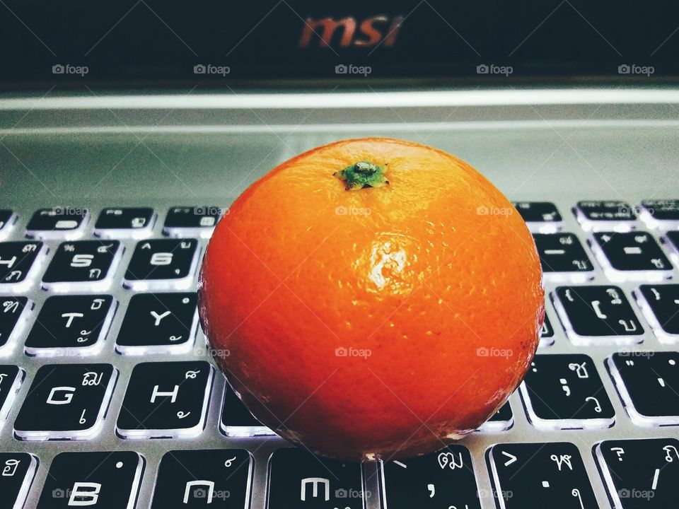 Orange on keyboard of laptop