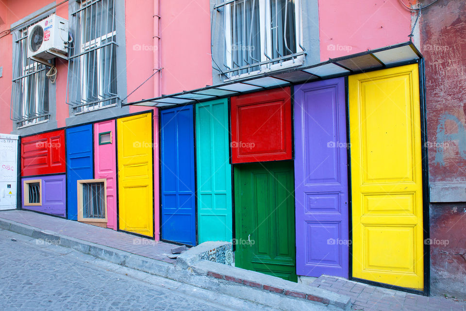the unusual design of old building with a few colorful doors
